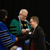 Student shaking hands with President